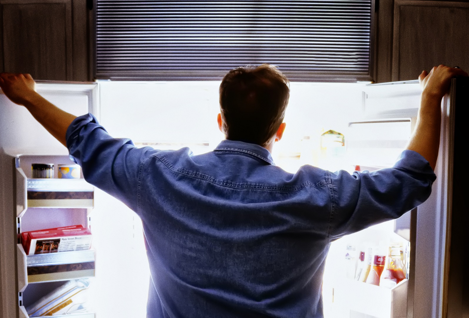 Man looking into refrigerator for food, refrigerator.