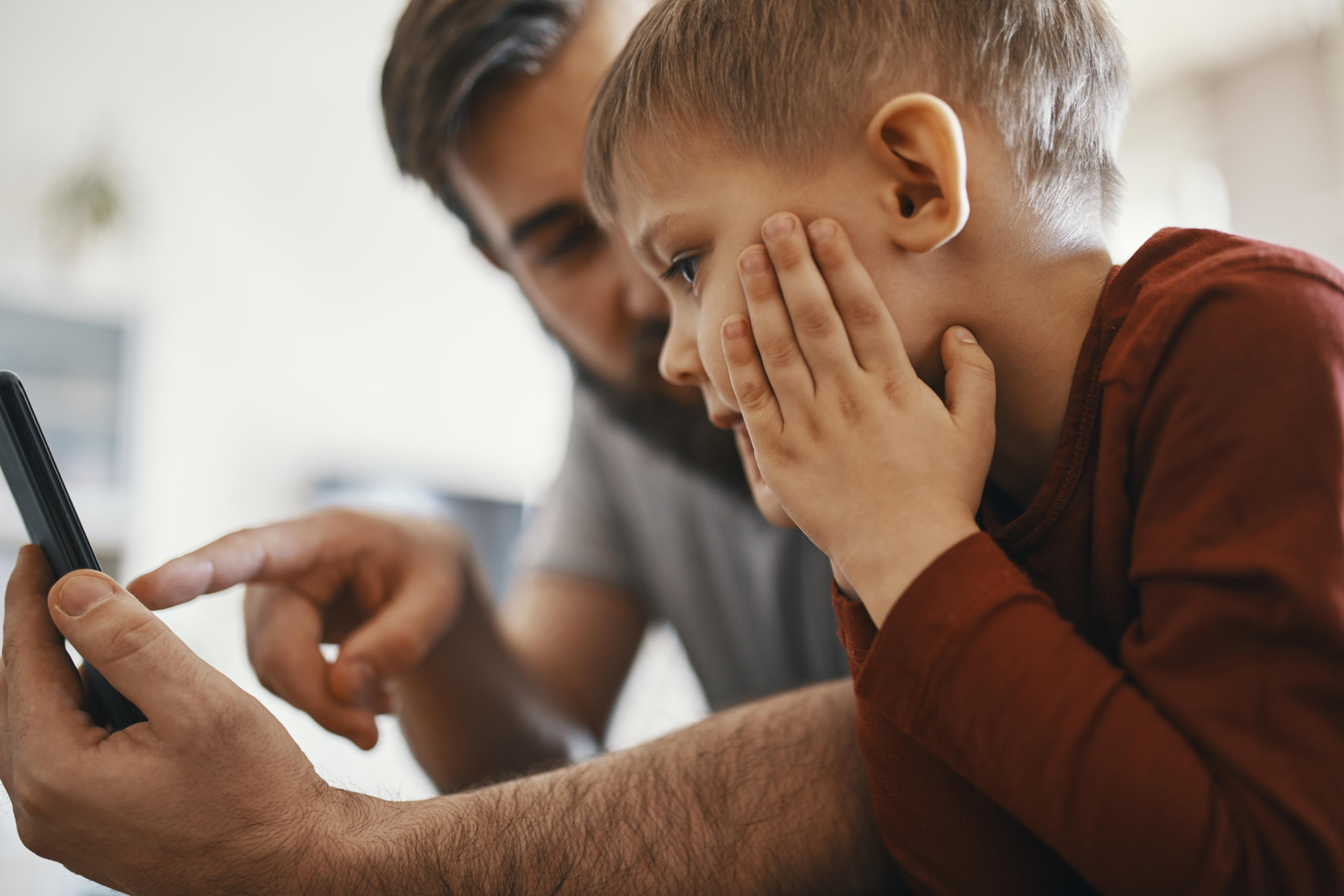 Father and son looking at the artificial pancreas on their phone