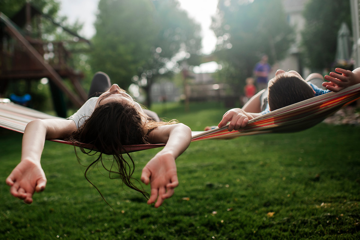 Children relaxing on a hammock on a summer evening