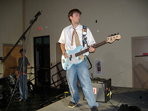 Josh playing guitar in high school with his insulin pump on display