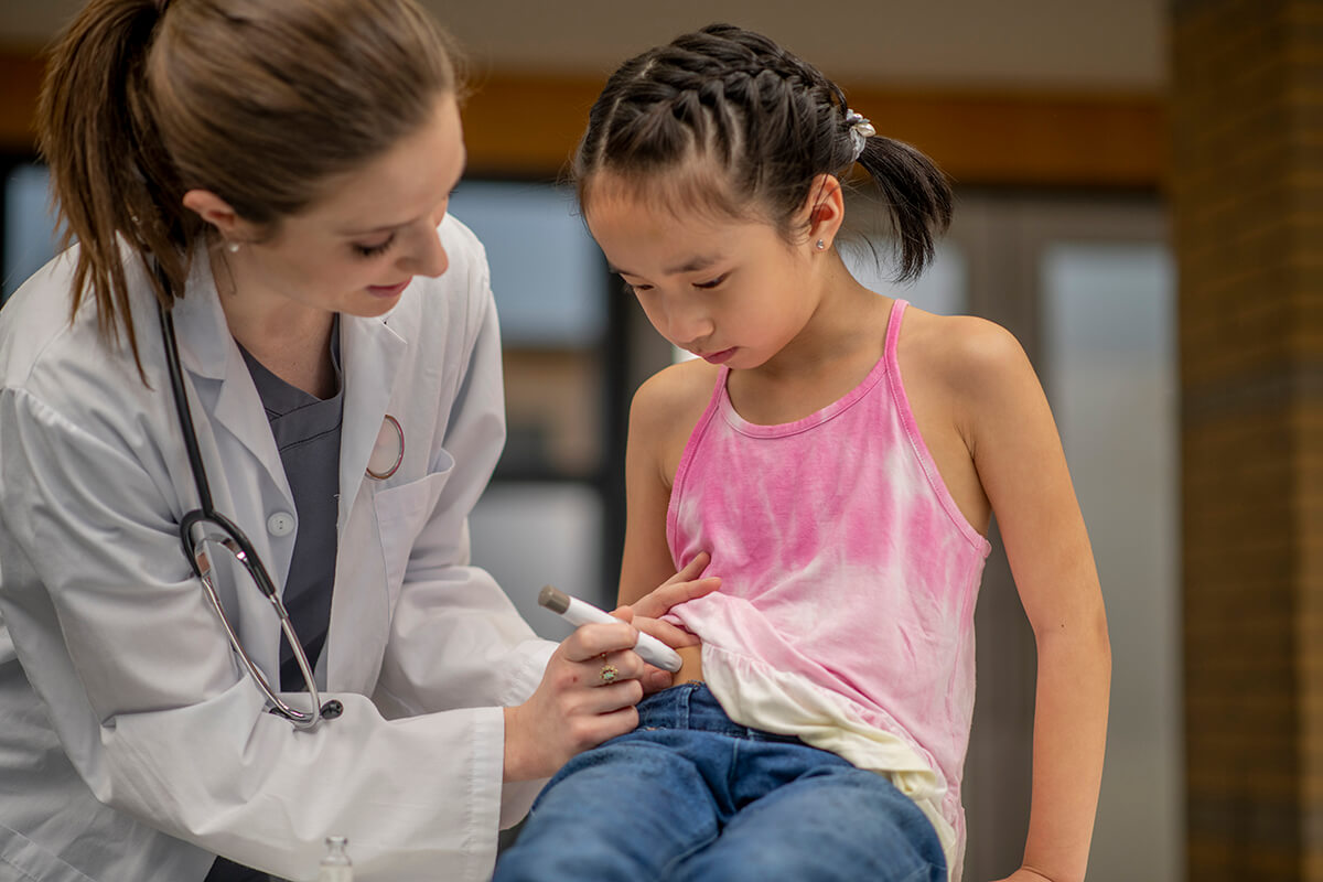 Nurse trains young girl on insulin injections