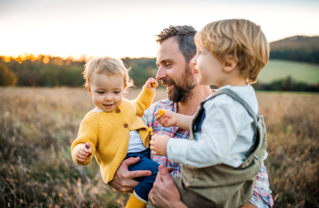 Father holding his two young children.