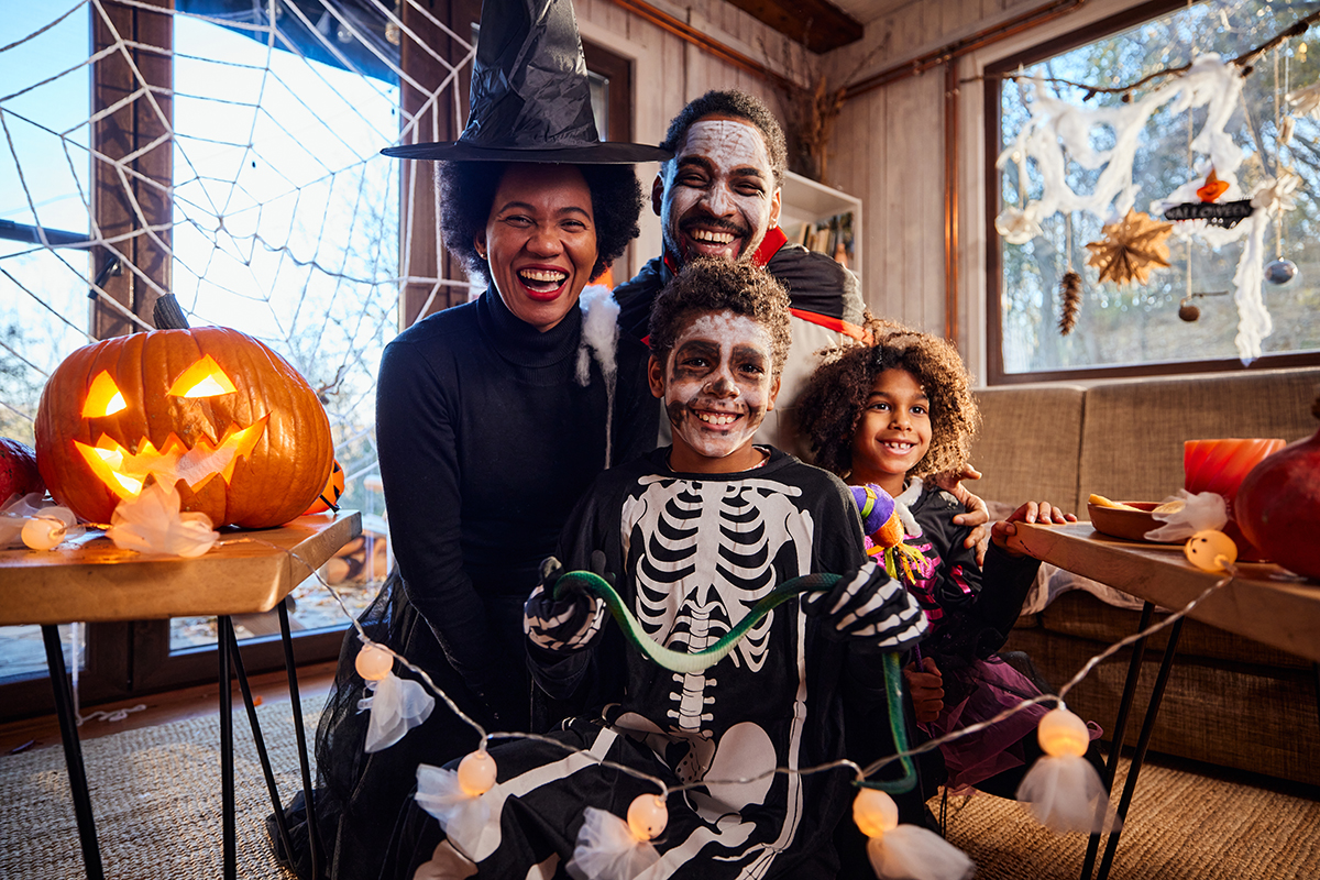 Happy Black family in costumes enjoying a Halloween celebration